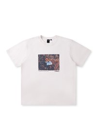T-shirt en coton blanc avec une impression graphique rectangulaire en couleur. Le visuel représente une fleur sur un fond naturel texturé.