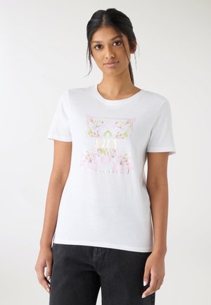 Maglietta bianca in cotone con maniche corte, con una grafica floreale in morbido rosa e verde, centrata sul davanti.