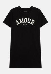 Černé bavlněné tričko s krátkým rukávem a kulatým výstřihem. Bílé nápis "AMOUR" přes hruď s malým designem křídla nahoře.
