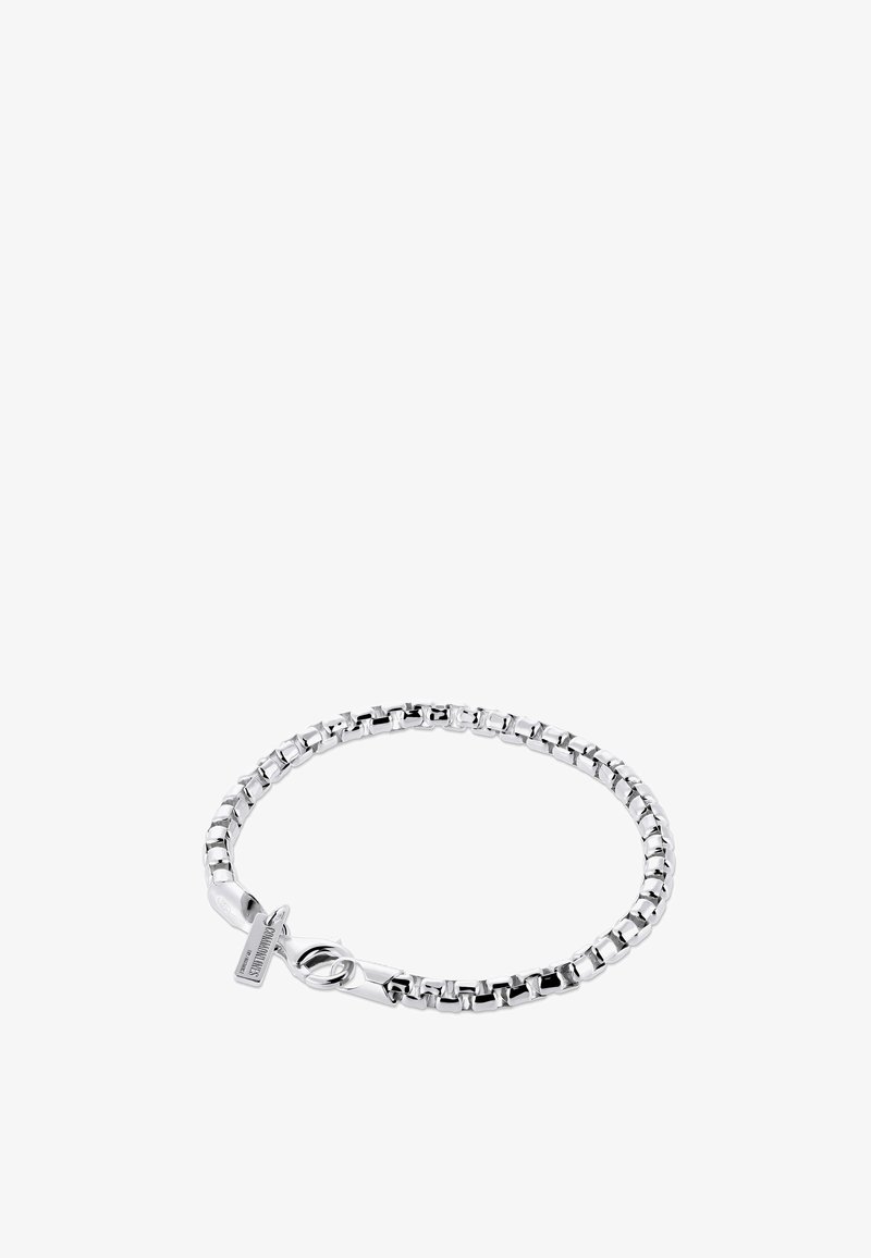 Bracelet chaîne boîte en argent avec fermoir mousqueton et petite étiquette rectangulaire près du fermoir sur fond blanc.