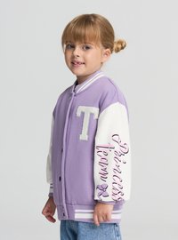 Fioletowo-biała kurtka varsity z dużą literą „T” na piersi, paskowanymi mankietami i napisem „Princess team” na rękawie. Materiał z mieszanki bawełny.
