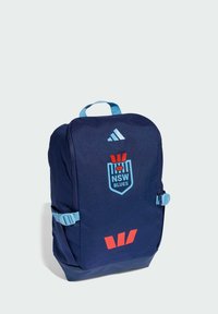 Mochila de tela azul con correas ajustables, con el logo de NSW Blues y detalles en rojo. Incluye un asa superior y hebillas laterales.