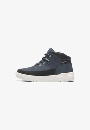 Mit einer Kombination aus dunkelblauem und schwarzem Synthetikmaterial, weißer Gummisohle, Metallöse und Logo an der Ferse, sind diese Mid-Top-Sneaker ausgestattet.
