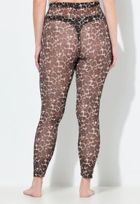 Průhledné legíny s hnědým leopardím vzorem, s přiléhavým střihem a černým páskem. Tkanina má hladkou strukturu.