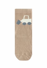 Chaussette beige avec un motif de tracteur bleu, présentant une texture côtelée et un orteil uni. Le tracteur a une carrosserie blanche et des roues bleu foncé.