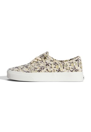 Baskets basses Vans avec motif floral beige, noir et vert clair et semelle blanche sur fond blanc.