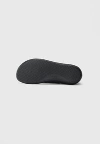 Black shoe sole with textured grip pattern and "TYR" logo centered on bottom, displayed against a plain white background.