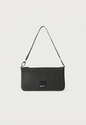 Sac à main rectangulaire tissé noir avec fermeture éclair, une courte bandoulière et un petit patch logo à l'avant.