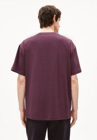 Korte mouw, ronde hals t-shirt in donkerpaars katoen, met een ontspannen pasvorm en platte naden. Glad textuur zonder zichtbare patronen.