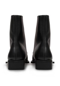 Schwarze Leder-Stiefeletten mit glatter Textur, quadratischer Zehenform und niedrigem Blockabsatz. Mit einer Rückennaht und dezenten seitlichen Akzenten.