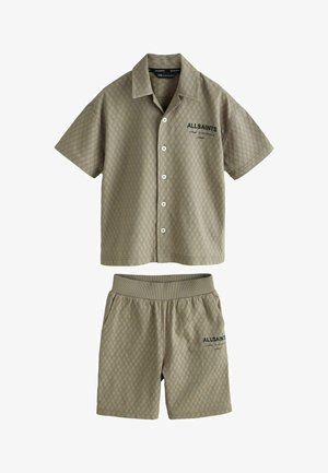 Rövid ujjú, galléros ing és rövidnadrág szett világoszöld, texturált anyagból; mindkét darabon gyémántminta és logórészletek találhatók.