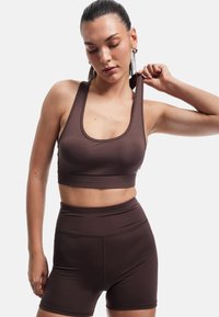 Brun atletisk crop top og højhalsede shorts lavet af glat, strækbart stof med minimalt antal sømme, der har en scoop halsudskæring og brede stropper.