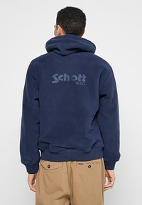 Marineblauwe fleece hoodie met een groot, subtiel "Schott N.Y.C." logo op de achterkant, geribde manchetten en een capuchon met trekkoord.