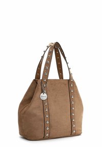 Sac fourre-tout en suède de couleur brun clair, avec des poignées clouées, une étiquette argentée et un design décontracté avec un intérieur spacieux.