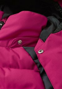 Giacca imbottita magenta con una texture morbida, fodera nera, bottoni a pressione metallici lucidi e sezioni trapuntate per isolamento e calore.