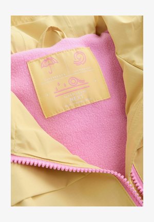 Žltá nepremokavá bunda s ružovou zatepľujúcou podšívkou z fleecu. Na bunde je štítok so symbolmi nepremokavosti a vetruodolnosti, s ružovým zipsom ako akcentom.