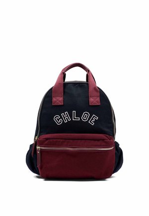 Mochila pequeña con parte superior negra y parte inferior granate, asas granate, bolsillo frontal con cremallera y texto "CHLOE" en la sección negra.