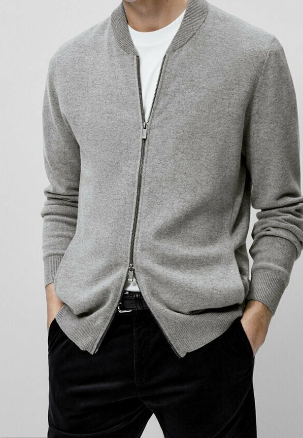 Szary kardigan na zamek wykonany z miękkiego materiału, z prążkowanym kołnierzem i mankietami, noszony na gładkiej białej koszuli, w połączeniu z ciemnymi spodniami.