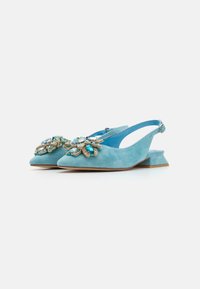 Scarpe slingback in suede azzurro chiaro con tacco basso a blocco e complicate decorazioni di gioielli sulla punta a forma di punta.