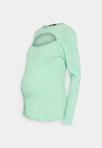 Blusa de maternidade de mangas longas em verde menta, com um decote redondo, contendo um recorte abaixo do decote e um design justo para conforto.