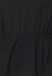 Tessuto nero con una vita arricciata, caratterizzato da una consistenza liscia e una leggera lucentezza. Il materiale appare leggero e fluente.