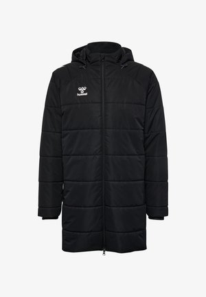 Sort puffermantel med lynlåslukning, justerbar hætte, quiltet design og Hummel-logoet på brystet. Har sidelommer.