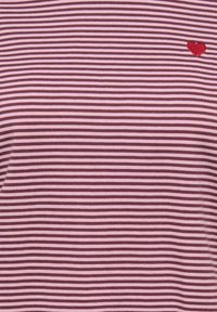 Gestreept T-shirt in roze en bordeauxrood, gemaakt van zachte stof, met een klein rood hartje geborduurd aan de linkerkant.