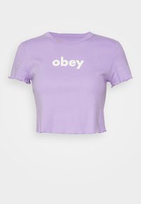 Fialové zkrácené tričko s kulatým výstřihem a krátkými rukávy. Na přední straně se nachází bíle tištěný text "obey". Měkká látka a surové okraje.