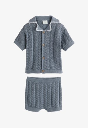 Plava pletena dječja odjeća s kardiganom kratkih rukava i gumbima te pripadajućim kratkim hlačama, s teksturiranim uzorkom kabel pletenja.