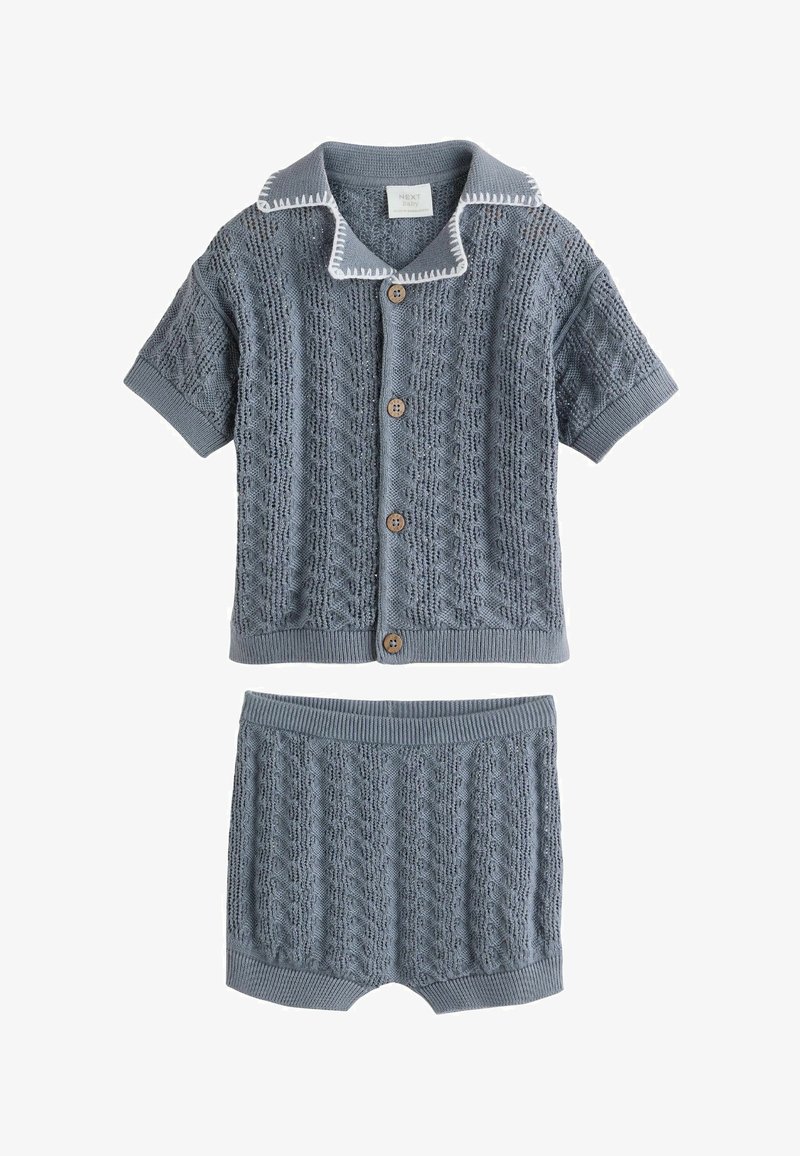 Kék kötött babaruha rövid ujjú gombos kardigánnal és hozzáillő rövidnadrággal, texturált kábelkötött mintával.