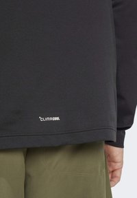 Black long-sleeve shirt made from breathable fabric, featuring a "ClimaCool" logo at the hem and a smooth, textured finish.
