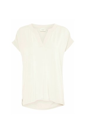 Cream-colored short-sleeve top with a relaxed fit, V-neckline, soft fabric, side hem slits, and a slightly longer back hem.