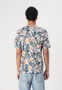 Tricou cu mâneci scurte, cu un imprimeu floral ce include flori roz și frunze verzi, confecționat dintr-un material ușor, cu o croială lejeră.