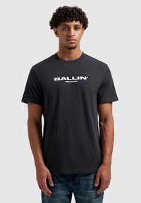 Zwart katoenen T-shirt met korte mouwen, met een witte "BALLIN'"-logo op de borst. Eenvoudig ontwerp met een ronde hals.