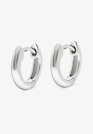 Une paire de boucles d'oreilles en argent poli, de conception chunky et arrondie, avec un fermoir charnière sur fond blanc.