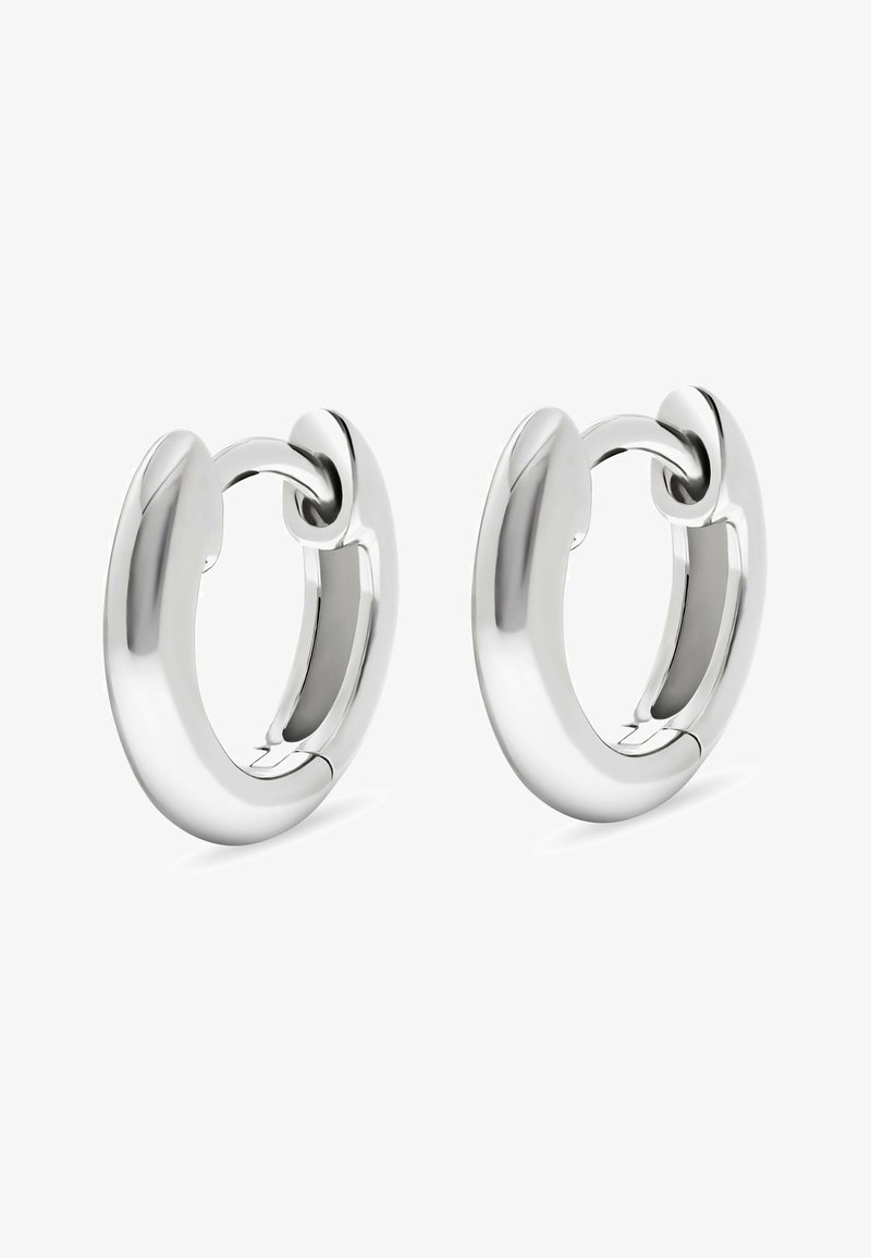 Un paio di orecchini a cerchio in argento lucido con un design spesso e arrotondato e chiusura a cerniera su uno sfondo bianco.