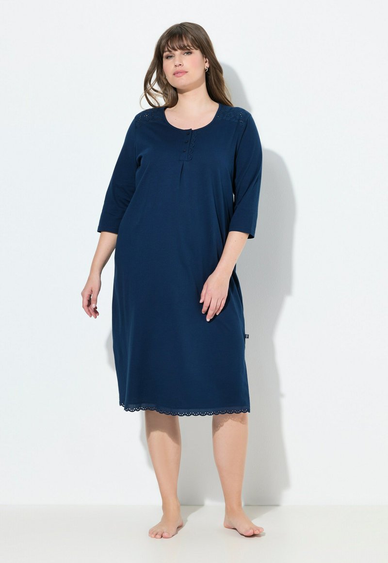 Granatowa nocna koszula z miękkiego materiału, okrągłym dekoltem, rękawami o długości 3/4, detalami w postaci guzików oraz falbaniastym wykończeniem.