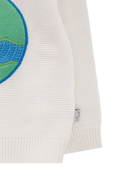 Pull en tricot blanc avec un patch circulaire incluant des détails en vagues vertes, bleues et bleues texturées. Poignets et ourlet côtelés. Petite étiquette de logo incluse.