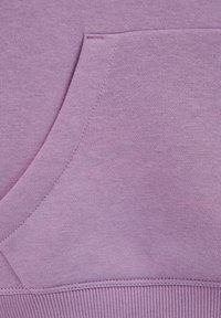 Lila sweatshirttyg med en framficka och ribbad nederkant. Slät textur med subtila sömnadsdetaljer.