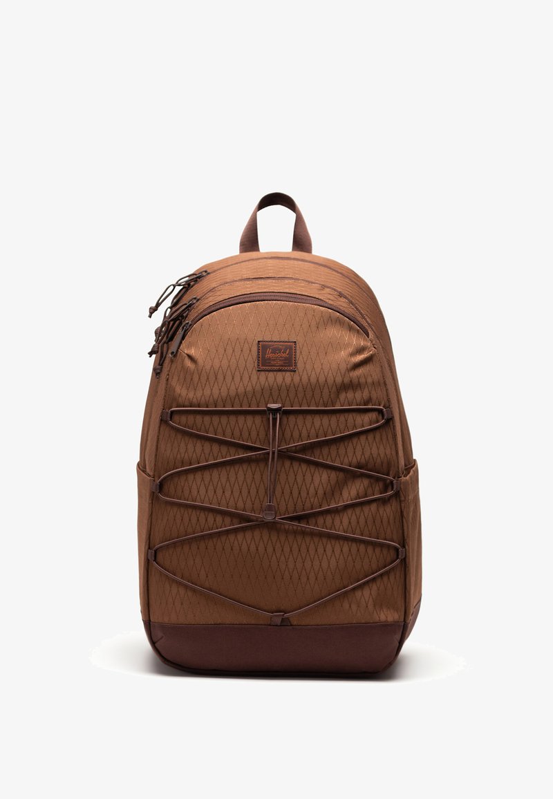 Sac à dos marron avec tissu à motif losange, deux compartiments zippés, un cordon élastique à l'avant et une poignée de transport sur le dessus.
