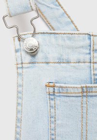 Light blue denim overalls feature adjustable straps attached with a silver metal clip, accented by orange stitching and a front pocket.