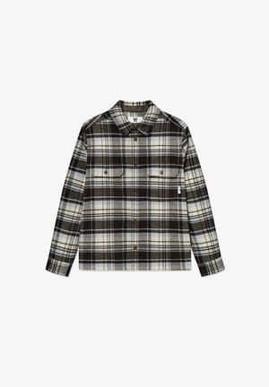 Koszula w kratę z materiału flanelowego w odcieniach czerni, bieli i jasnoniebieskiego. Posiada zapięcie na guziki w kieszeniach na piersi oraz kołnierzyk. Miękka tekstura.