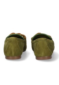Mocasines de ante verde con un acento trenzado, parte trasera redondeada y suelas marrones, que exhiben una textura suave y costuras decorativas.