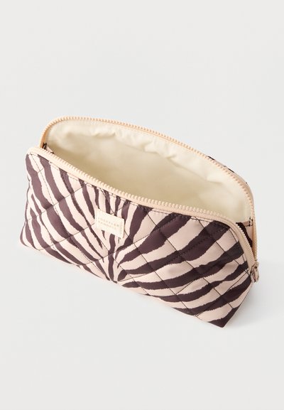 Ορθογώνια τσάντα με ραφή, με μαύρο και μπεζ σχέδιο ζέβρας, μπεζ φερμουάρ και εσωτερική φόδρα από κρεμ ύφασμα, ανεβασμένη και μερικώς ανοιχτή.