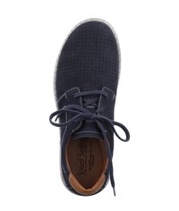 Tmavě modrá nubuková bota s perforovaným svrškem, kulatou špičkou a kontrastním hnědým pata. Obsahuje ploché tkaničky a světle zbarvenou podrážku.