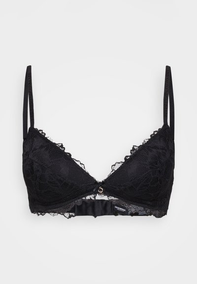 Black lace bralette with a floral pattern, adjustable straps, a central silver accent, and scalloped edges. Soft, semi-sheer texture.