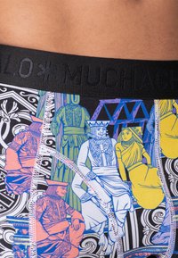 Színes, mintás boxer alsónadrágok részletes illusztrációkkal történelmi alakokról, fekete elasztikus derékpánttal. A dizájn merész színeket és részleteket tartalmaz.