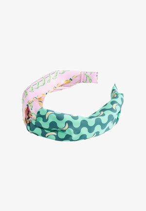 Twisted fabric headband with two patterns: pink with yellow bananas, and green with wavy dark green shapes and bananas.