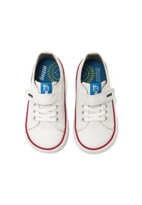 Zapatillas de lona blancas con acentos rojos, que cuentan con cordones elásticos y una correa de velcro. El interior tiene una plantilla azul con un gráfico de sol. Suela plana y redondeada.