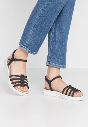 Sandalias negras con tiras y plataforma texturizada, con múltiples tiras sobre los dedos y el tobillo, con una hebilla para ajustar.